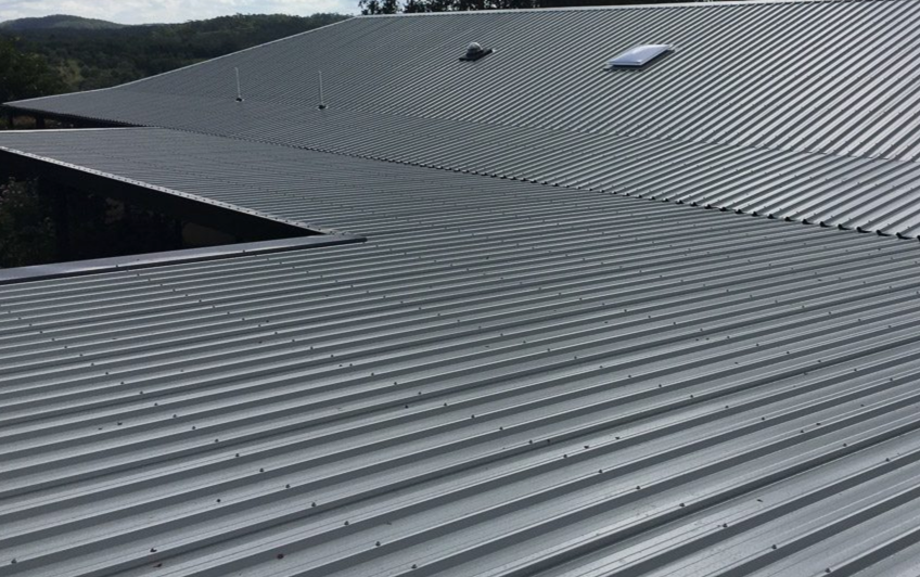 Commercial metal roof restoration and repair on a large building in Austin.