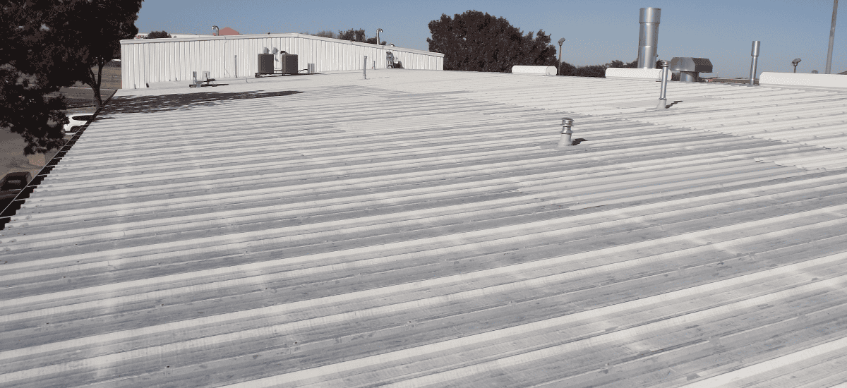 Commercial metal roof showing signs of wear and needing restoration.