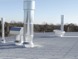 Commercial metal roof with ventilation pipes and flashing, Austin TX.