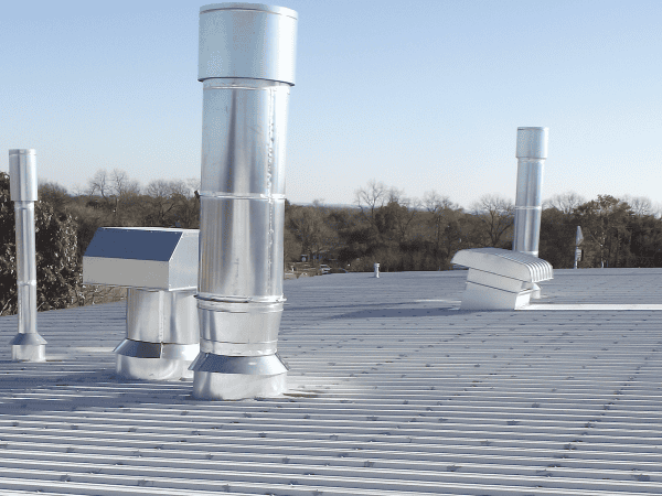 Commercial metal roof with ventilation pipes and flashing, Austin TX.